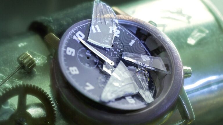 Разбитые механические часы с осколками стекла